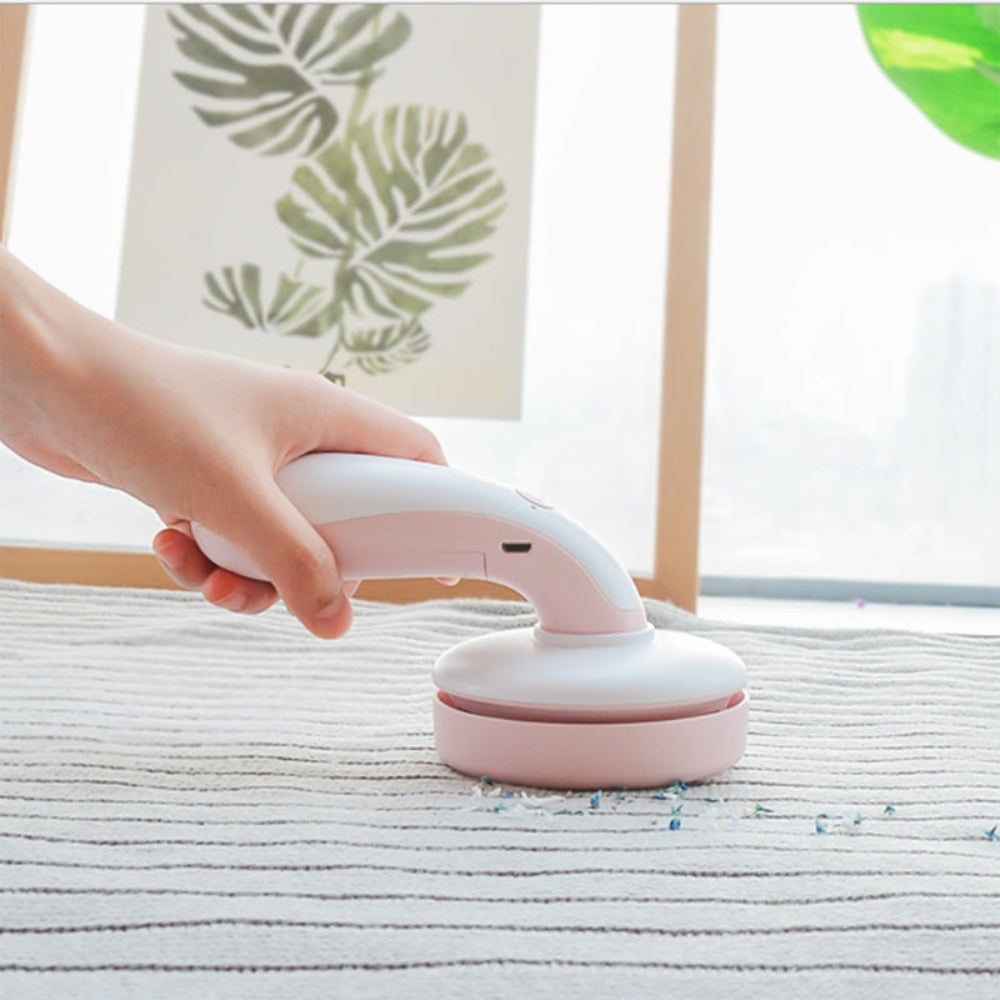 "Handheld vacuum or scrubber being used on a textured home surface, professional lifestyle product photography for home cleaning gadgets."