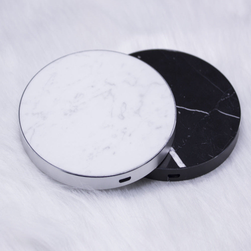 "Two circular electronic devices, one minimalist solid white and one premium black marble-patterned, displayed on a light gray background."