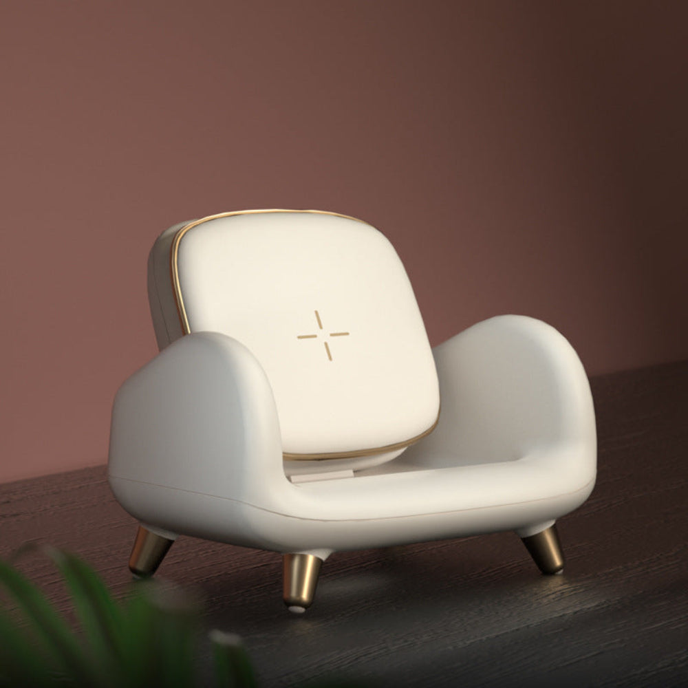 Sofa-style wireless charging dock with gold accents on a modern desk setup 